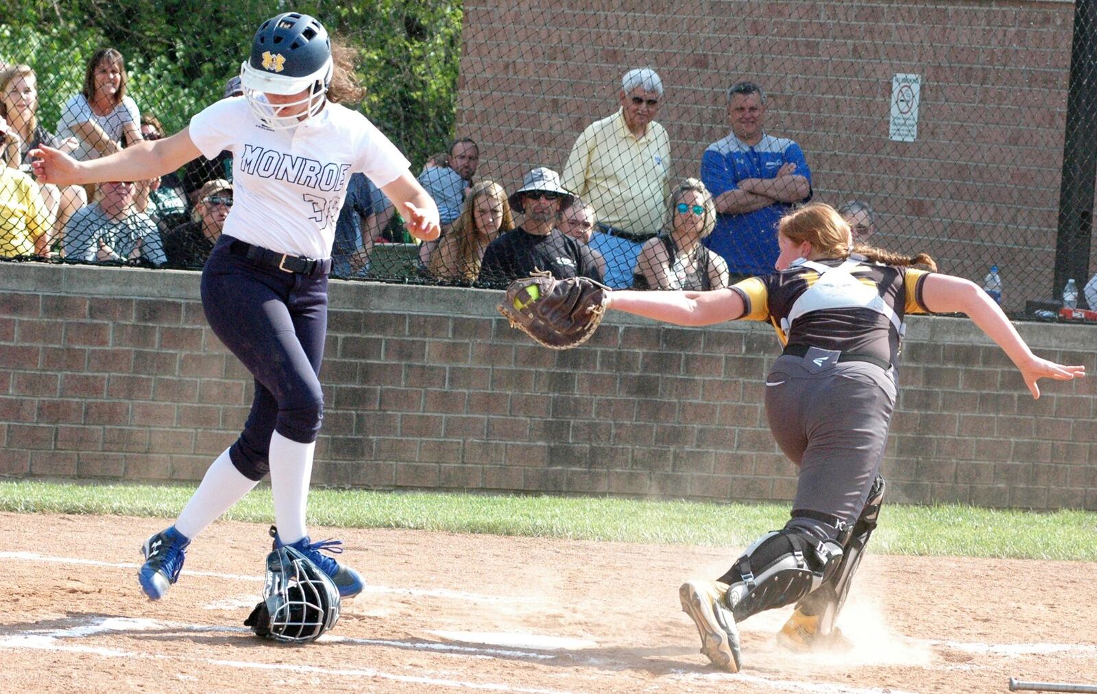 Monroe’s Emily Mullins is safe at home plate ahead of the throw to Springfield Shawnee catcher Alise Moneypenny during Saturday’s Division II district championship softball game at Brookville. Monroe won 4-0. RICK CASSANO/STAFF