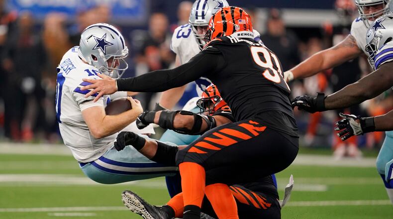 Cincinnati Bengals defensive end Sam Hubbard, bottom, sacks Dallas Cowboys quarterback Cooper Rush (10) along with Cincinnati Bengals defensive end Trey Hendrickson (91) during the second half of an NFL football game Sunday, Sept. 18, 2022, in Arlington, Tx. (AP Photo/Tony Gutierrez)