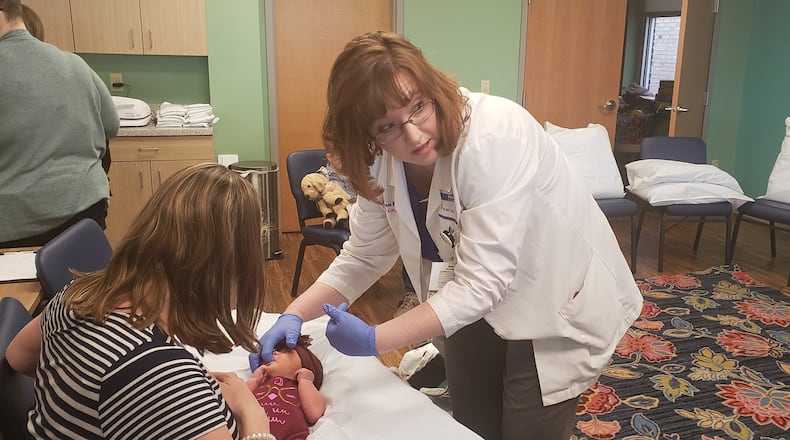 Heather Evans, Baby Cafe facilitator and the lactation clinical lead at UC Health West Chester Hospital, helps a mother to nurse her baby at the grand opening of Baby Cafe Monday, March 9, 2020. The program at 210 South Second St. is a partnership between UC Health, WIC and Primary Health Solutions. ERIC SCHWARTZBERG/STAFF