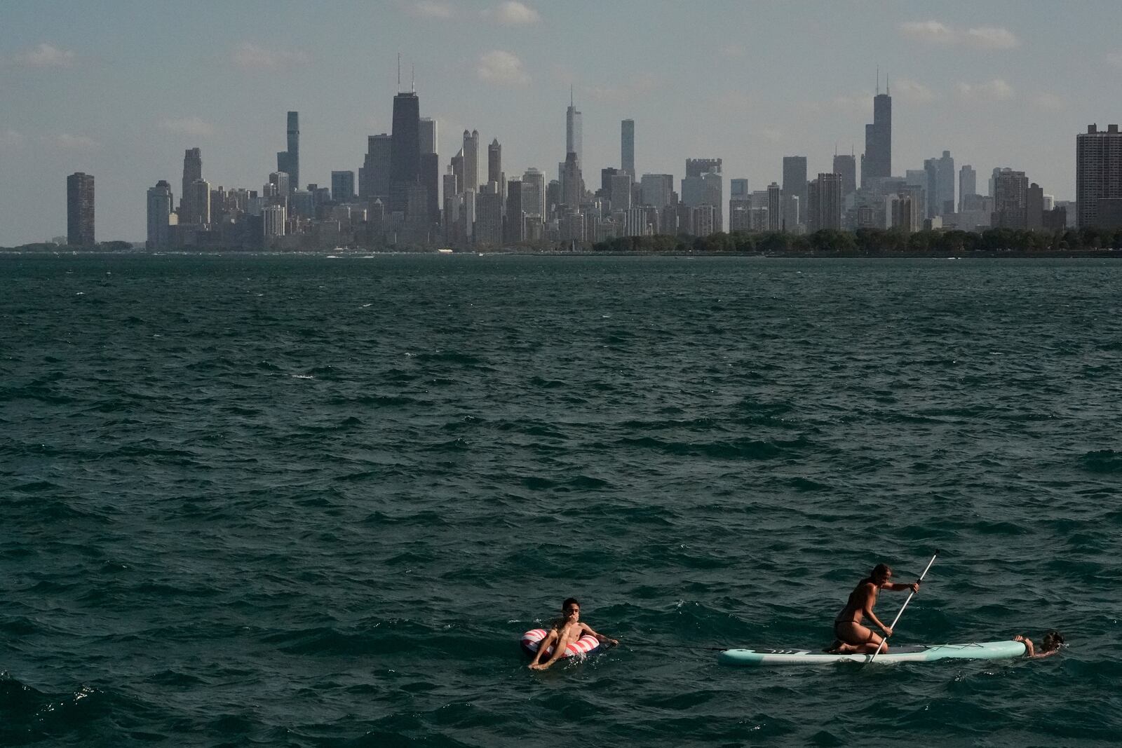 People cool off in a Lake Michigan shore Sunday, June 22, 2025, in Chicago. (AP Photo/Kiichiro Sato)