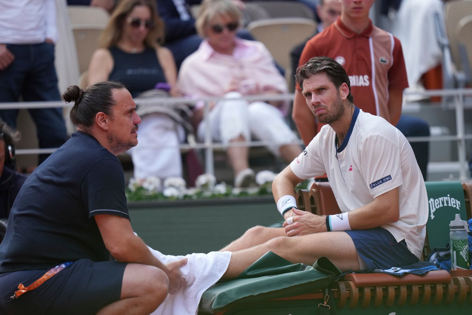 Britain's Cameron Norrie receives medical assistance during the fourth round match of the French Tennis Open against Serbia's Novak Djokovic at the Roland-Garros stadium in Paris, Monday, June 2, 2025. (AP Photo/Thibault Camus)
