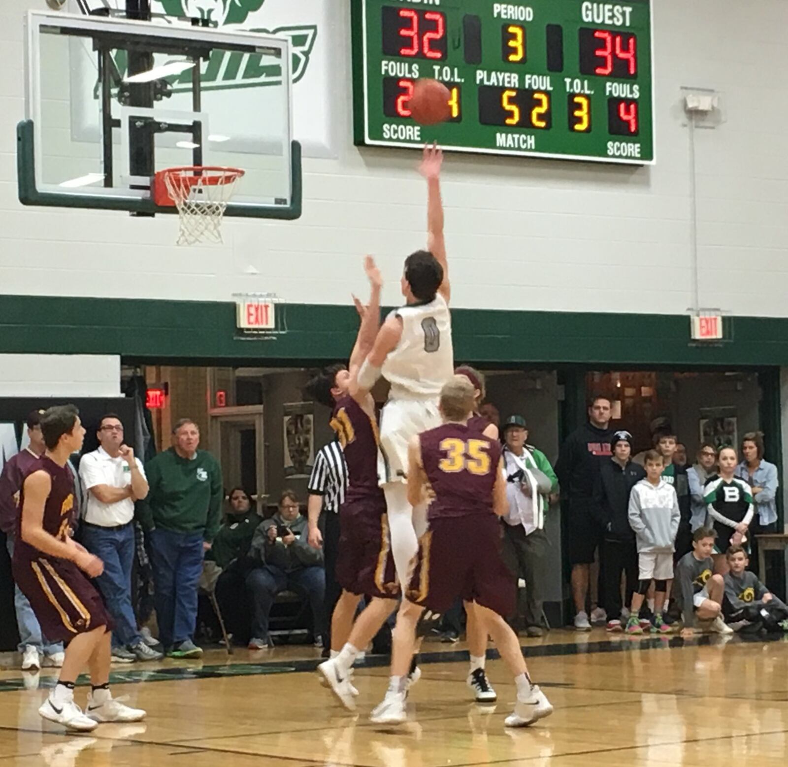 Badin’s Jakob Tipton (0) shoots between Sean Lange (31) and Cody Geers (35) of Ross during Saturday night’s game at Mulcahey Gym in Hamilton. RICK CASSANO/STAFF