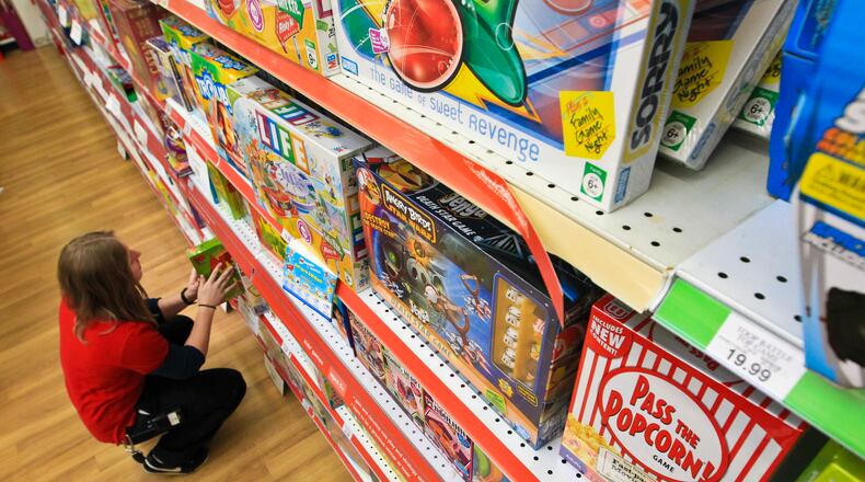 Beavercreek Toys “R” Us sales associate Devin Algren stocked the game shelves in preparation of the holiday shopping season in 2012. Staff photo by Jim Witmer