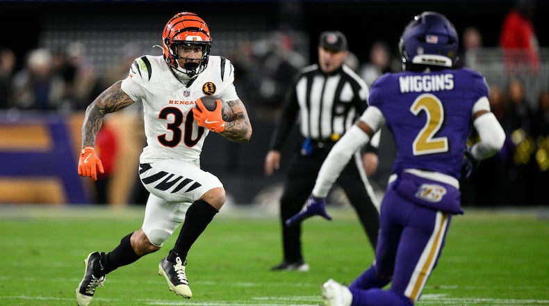 Cincinnati Bengals running back Chase Brown (30) runs with the ball against Baltimore Ravens cornerback Nate Wiggins (2) during the first half of an NFL football game, Thursday, Nov. 27, 2025, in Baltimore. (AP Photo/Nick Wass)