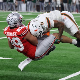 Miami defensive back Jakobe Thomas, right, makes a tackle on Ohio State tight end Will Kacmarek during the second half of the Cotton Bowl College Football Playoff quarterfinal game Wednesday, Dec. 31, 2025, in Arlington, Texas. (AP Photo/Gareth Patterson)