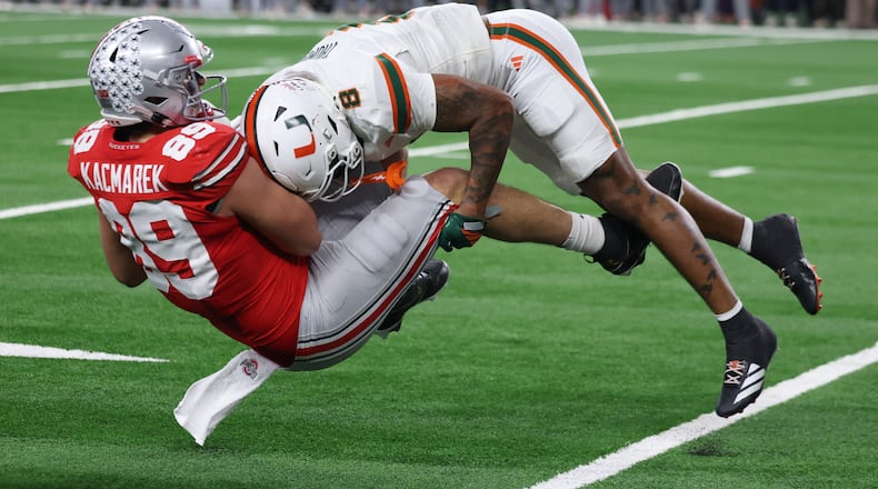 Miami defensive back Jakobe Thomas, right, makes a tackle on Ohio State tight end Will Kacmarek during the second half of the Cotton Bowl College Football Playoff quarterfinal game Wednesday, Dec. 31, 2025, in Arlington, Texas. (AP Photo/Gareth Patterson)
