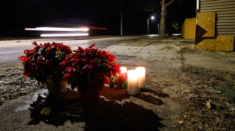 Flowers and candles were left near the intersection of River Road and Hooven Avenue on Sunday, Dec. 21, 2025. The area was the site of a crash that killed three people earlier in the day. NICK GRAHAM / STAFF