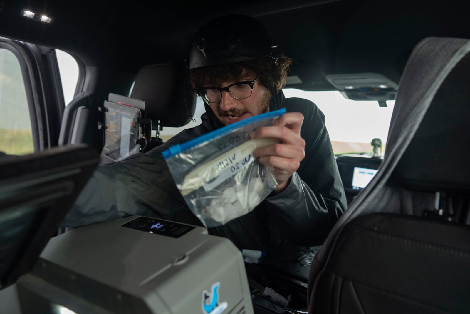 Tony Illenden turns to place a bag of hail he collected into a cooler in the backseat of the Northern Illinois University's Husky Hail Hunter during a Project ICECHIP operation Friday, June 6, 2025, in Levelland, Texas. (AP Photo/Carolyn Kaster)