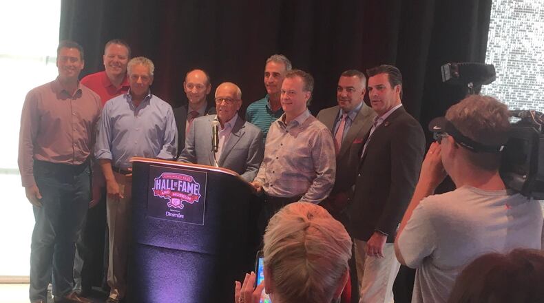 Marty Brennaman poses for a photo with his fellow Reds broadcasters after a press conference at the Reds Hall of Fame and Museum on Friday, Aug. 16, 2019, at Great American Ball Park in Cincinnati.