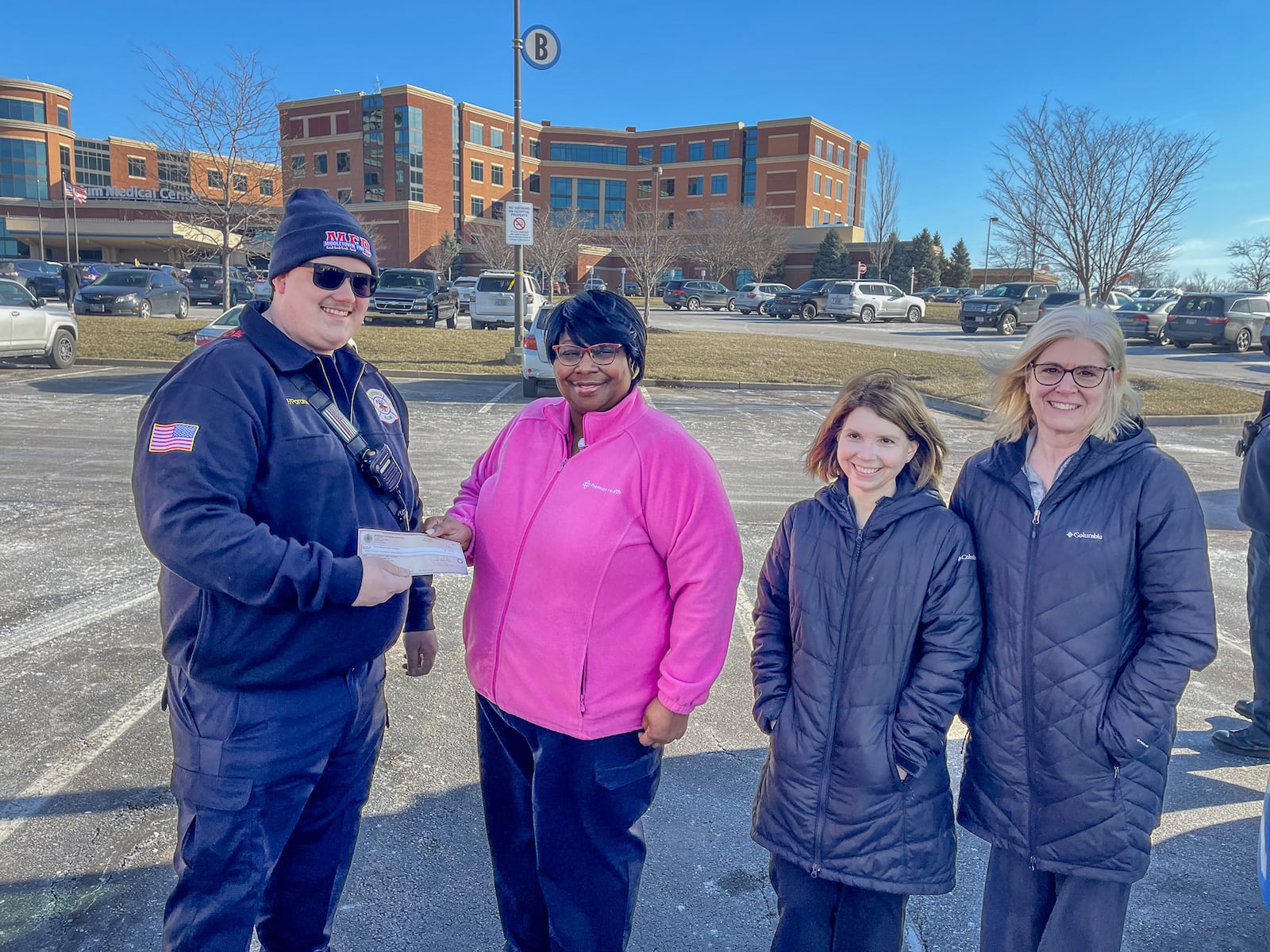 Middletown firefighter Jacob Moore presents a check to Ronice Powell, coordinator of Premier Health Mobile Mammography Coach, as Beth Riley, lead mammography technician, Atrium Medical Center Breast Center, and Theresa Gustafson, manager of breast imaging, Premier Health, look on. SUBMITTED PHOTO

