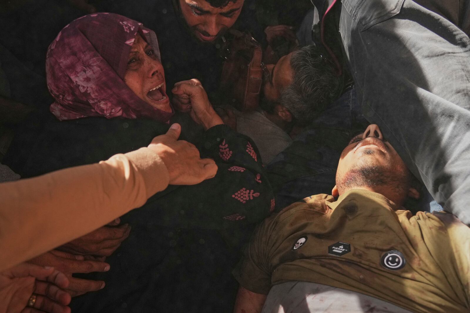 A woman reacts over the bodies of some of the victims of an Israeli army strike on a restaurant, which killed at least 29 people, as they are carried from the scene to a hospital in Gaza City, Wednesday, May 7, 2025.(AP Photo/Jehad Alshrafi)