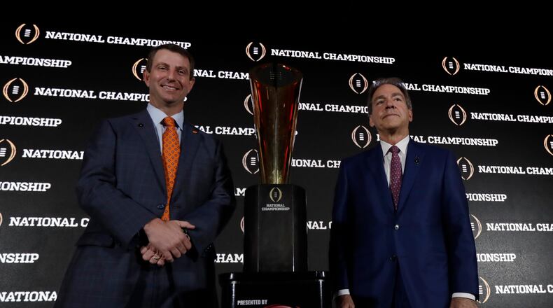 Clemson head coach Dabo Swinney and Alabama head coach Nick Saban pose with the championship trophy during a news conference for the NCAA college football playoff championship game Sunday, Jan. 8, 2017, in Tampa, Fla. (AP Photo/David J. Phillip)
