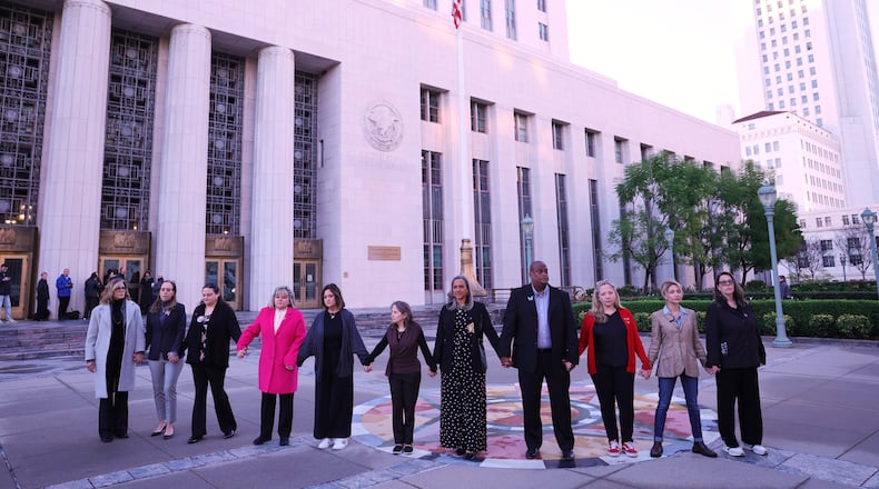 FILE - A group holds hands outside a landmark trial over whether social media platforms deliberately addict and harm children, Wednesday, Feb. 18, 2026, in Los Angeles. (AP Photo/Ryan Sun, File)