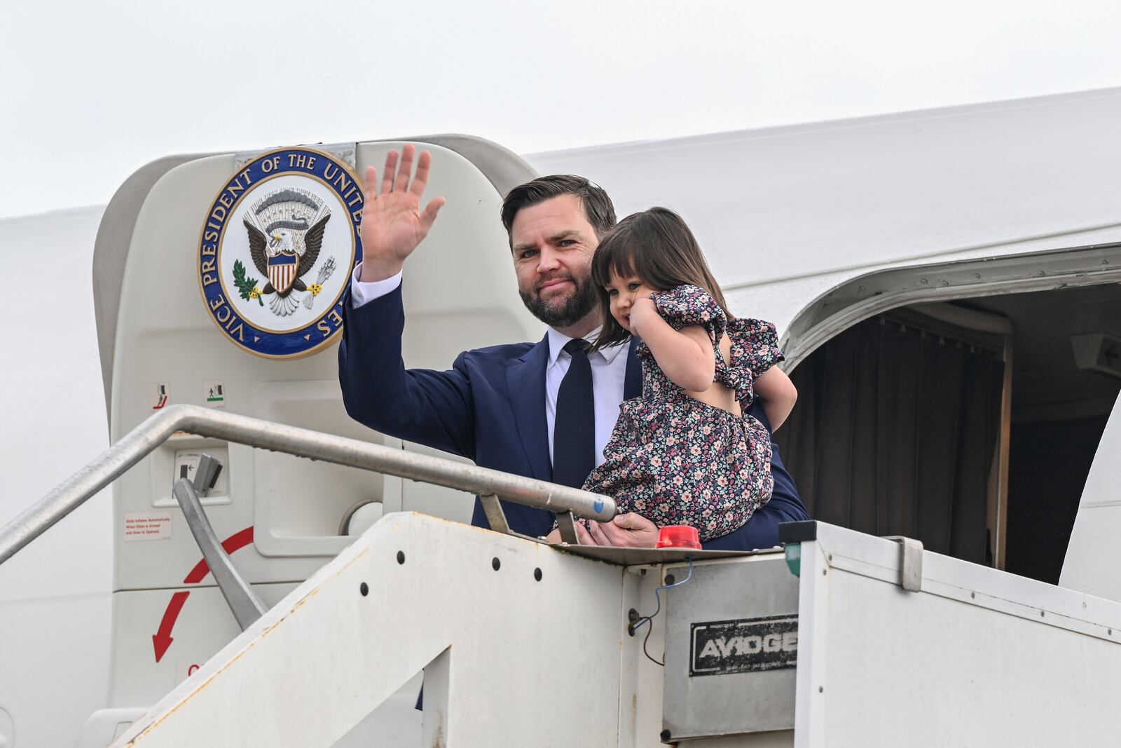 Vice President JD Vance disembarks Air Force Two while carrying his daughter Mirabel, upon arriving at G.B. Pastine–Rome Ciampino Airport, Friday April 18, 2025. (Kenny Holston/The New York Times via AP, Pool)