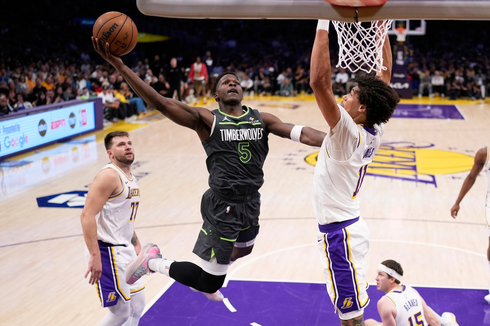 Minnesota Timberwolves guard Anthony Edwards, center, shoots as Los Angeles Lakers center Jaxson Hayes, right, and guard Luka Doncic defend during the first half in Game 1 of an NBA first-round playoff series Saturday, April 19, 2025, in Los Angeles. (AP Photo/Mark J. Terrill)
