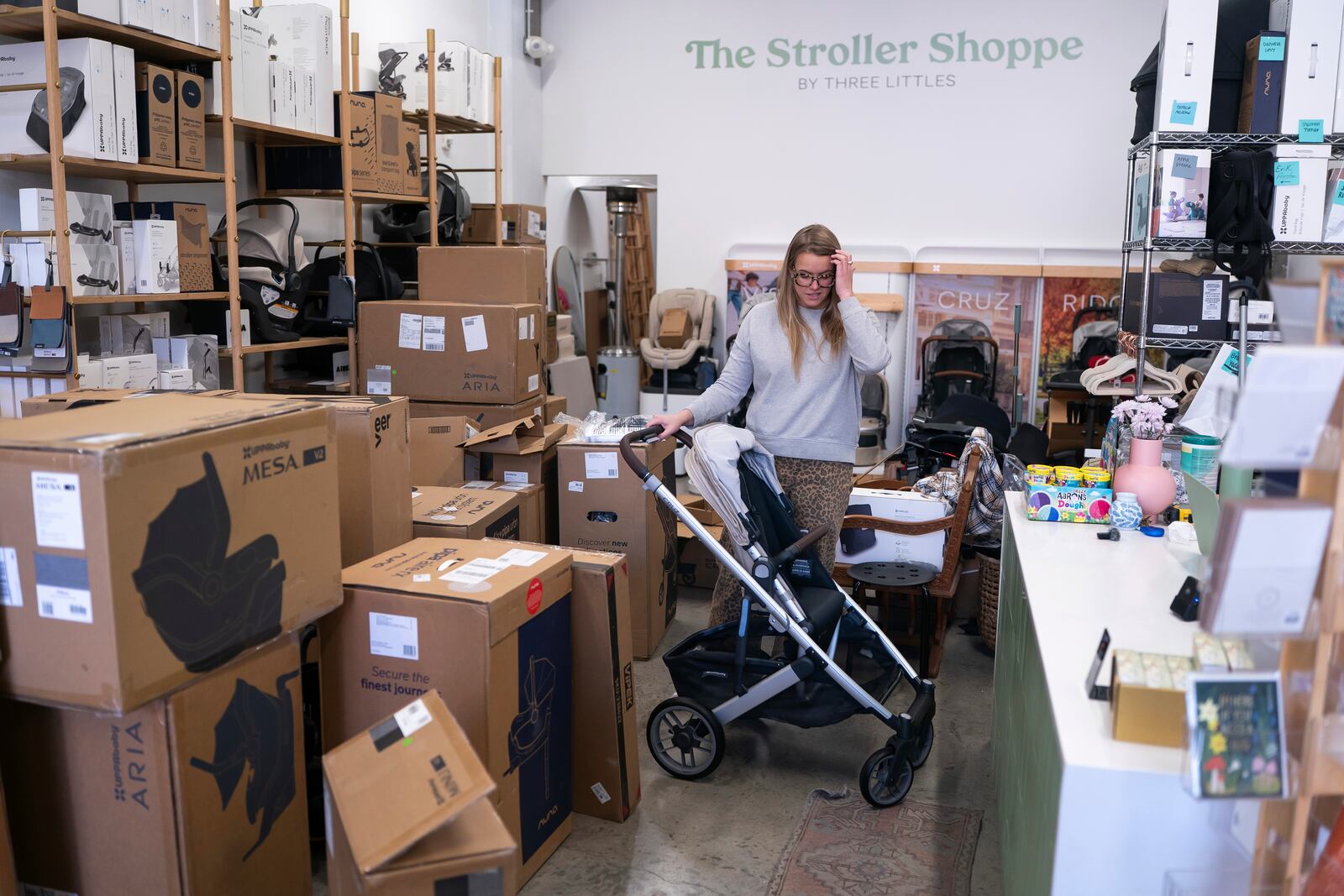 Elizabeth Mahon, owner of baby store Three Littles, unpacks strollers and other inventory ordered by customers ahead of tariff-driven price increases at her Union Market location in Washington, on Wednesday, April 16, 2025. (AP Photo/Nathan Howard)