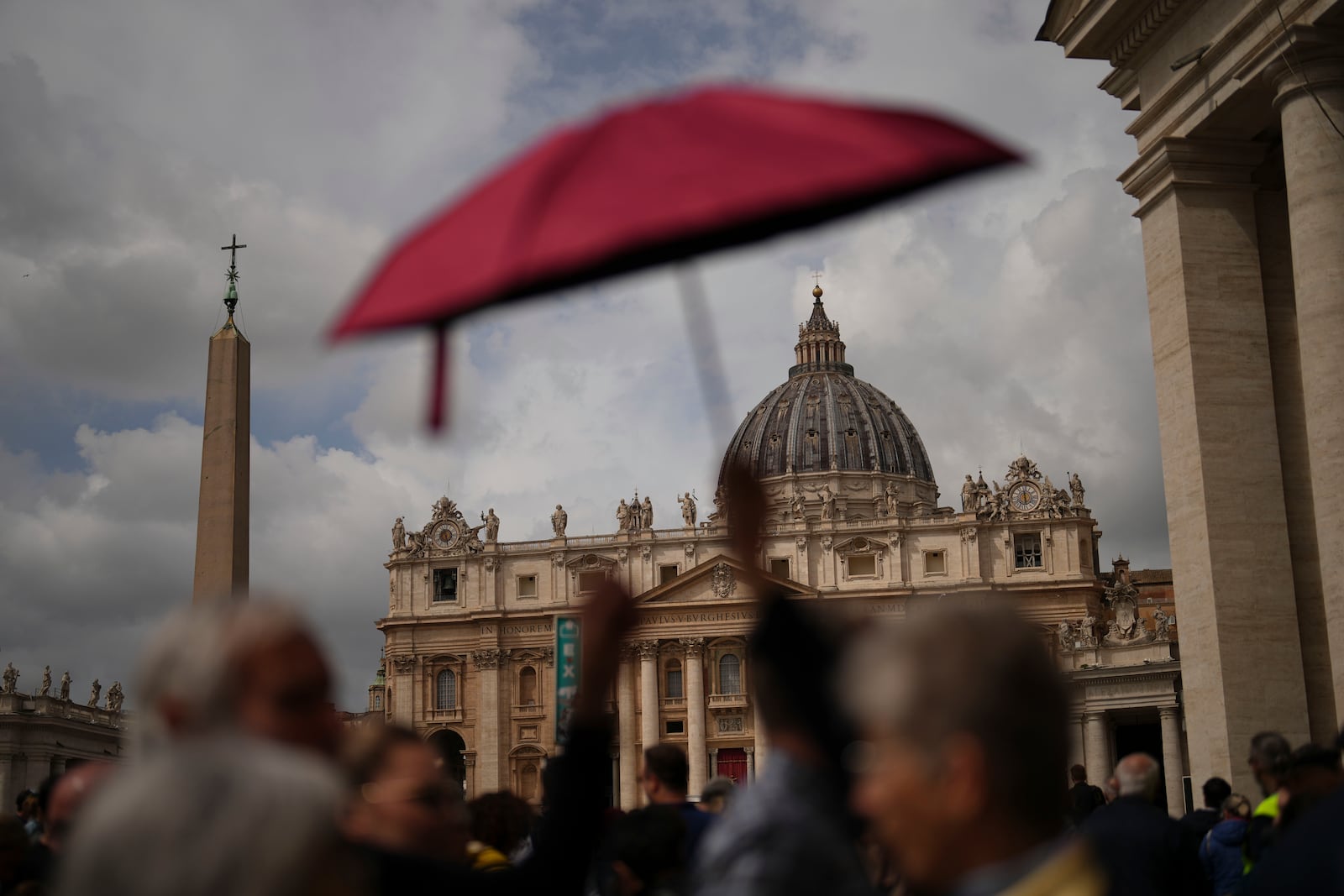 People wait in line under the rain to enter St.Peter's Basilica to view Pope Francis lying in state, at the Vatican, Thursday, April 24, 2025. (AP Photo/Francisco Seco)