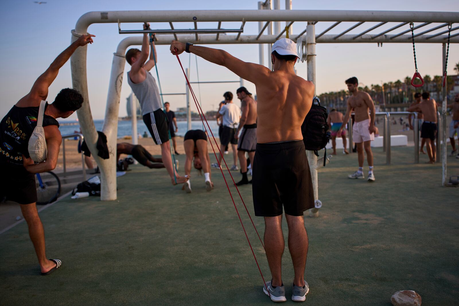 People work out in an open-air gym next to the beach in Barcelona, Spain, Tuesday, June 25, 2025. (AP Photo/Emilio Morenatti)