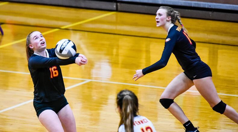 Fenwick’s Grace Maziar bumps the ball while being flanked by teammates Bella DeSalvo (13) and Kate Hafer (12) during their 3-0 victory over McNicholas on Thursday night in a Division II regional volleyball semifinal at Butler’s Student Activity Center in Vandalia. NICK GRAHAM/STAFF