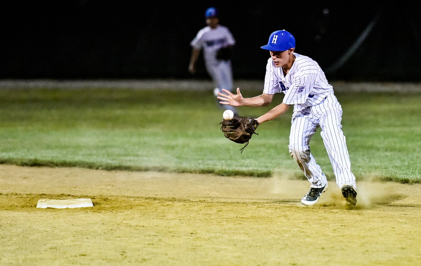 Hamilton West Side shortstop Noah Prewitt fields a ground ball Thursday night during a 15-0 triumph over Hamilton-Fairfield in the Little League District 9 championship game at West Side. NICK GRAHAM/STAFF