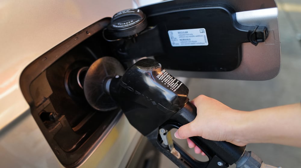 A person fills up her vehicle's gas tank at a gas station in Buffalo Grove, Ill., Thursday, March 19, 2026. (AP Photo/Nam Y. Huh)