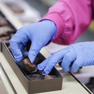 An Esther Price worker places a piece of candy into a box of assorted chocolates on Tuesday, March 3 at the company's production facility on Wayne Avenue in Dayton. The company is celebrating its 100th anniversary. BRYANT BILLING / STAFF