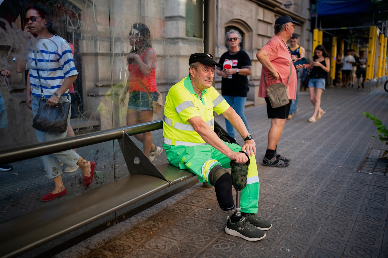 Raúl Rodriguez, 64, street cleaner, rests during a protest over the death of a street cleaner during a recent heat wave in Barcelona, Spain, Wednesday, July 16, 2025. (AP Photo/Joan Mateu Parra)