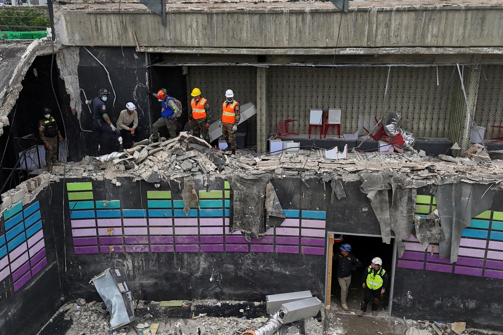 Rescue workers stand at site of the Jet Set nightclub days after its roof collapsed during a concert, killing more than 200 people in Santo Domingo, Dominican Republic, Thursday, April 10, 2025. (AP Photo/Matias Delacroix)