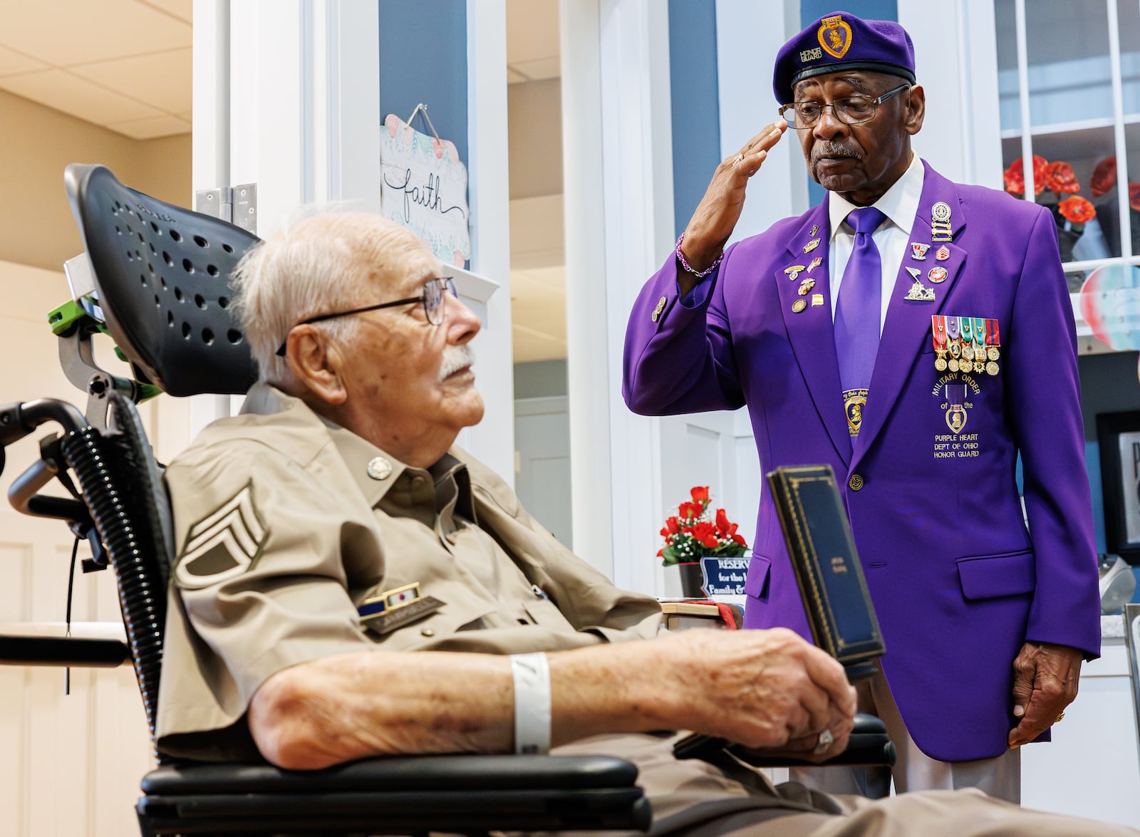 Jerry Ferris, the Ohio Commander of the Military Order of the Purple Heart, salutes Korean War veteran Leroy Campbell during a program on Tuesday at Victory Ridge on the campus of Dayton VA Medical Center. Ferris received three purple hearts while serving during the Vietnam War. Work is in progress for Campbell to receive a Purple Heart, but Ferris decided to give Campbell one of his medals. BRYANT BILLING / STAFF