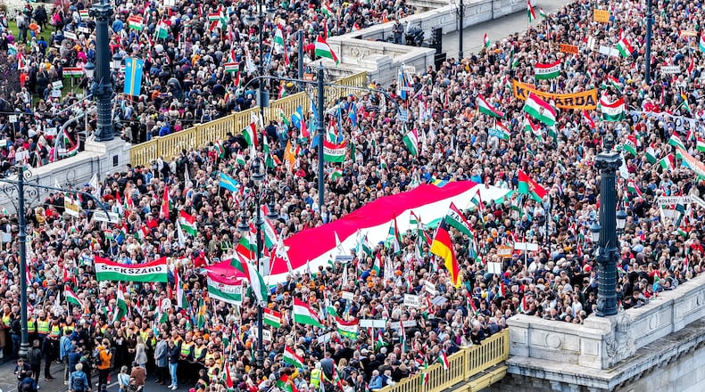 In this photo taken by a drone, participants of the Peace March organized by the pro-government Civil Unity Forum (COF) and its foundation Civil Unity Public Benefit Foundation (COKA) gather at the Buda side of Margaret Bridge in Budapest, Hungary, Thursday, Oct. 23, 2025, on the 69th anniversary of the Hungarian revolution and war of independence against communist rule and the Soviet Union in 1956. (Zsolt Czegledi/MTI via AP)