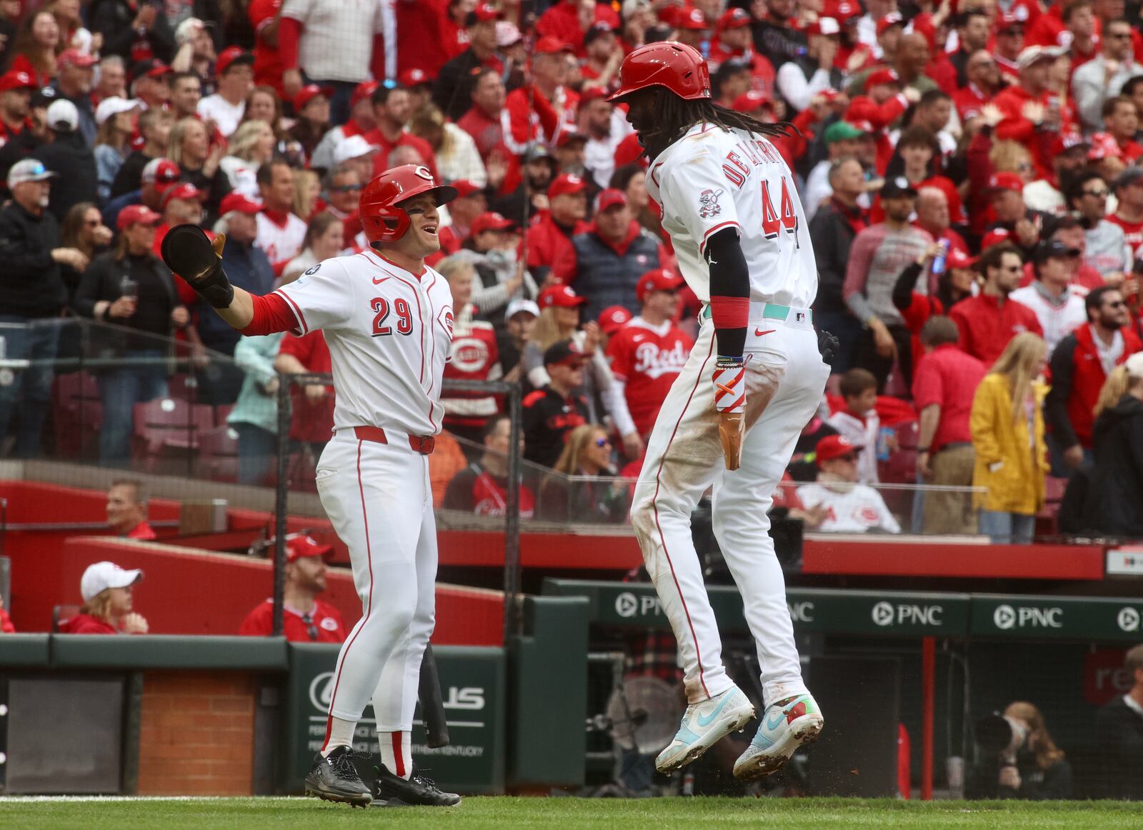 TJ Friedl, left, and Elly De La Cruz celebrate after scoring on a single by Jeimer Candelario in the third inning against the Giants on Thursday, March 27, 2025, on Opening Day at Great American Ball Park in Cincinnati. David Jablonski/Staff