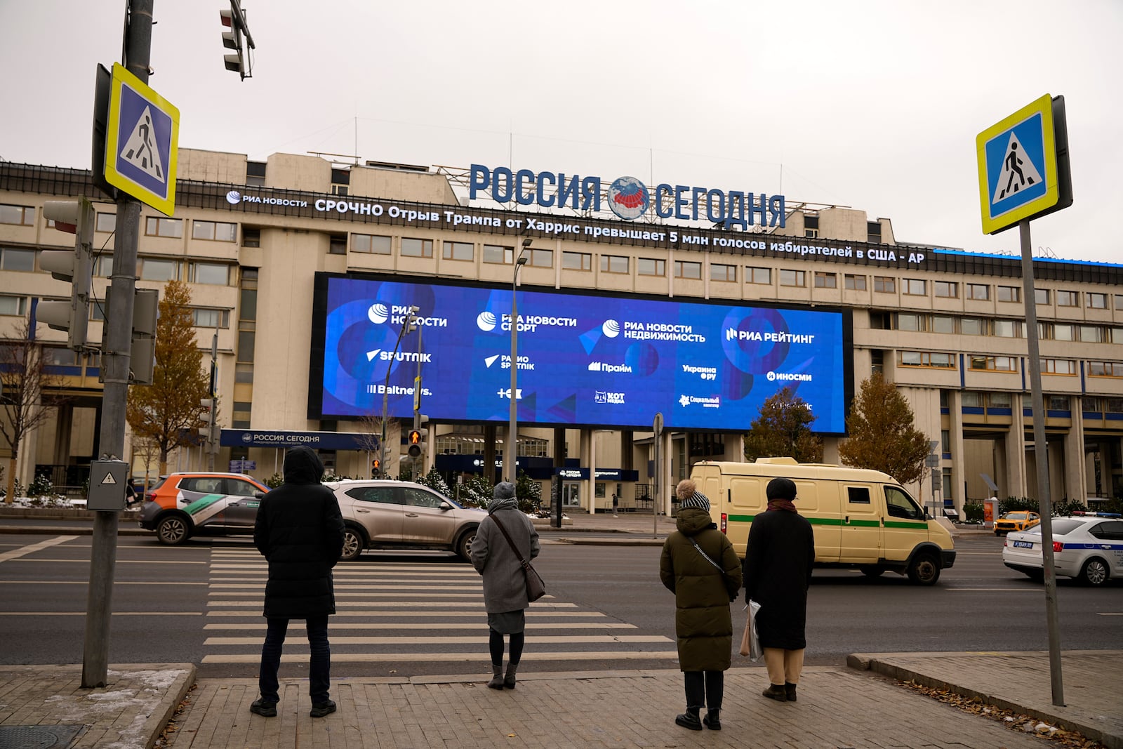 FILE - Pedestrians stand at the crossing in front of the Rossiya Segodnya International Media Group building in Moscow, Russia, on Nov. 6, 2024. (AP Photo/Pavel Bednyakov, File)