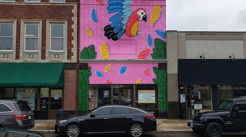 Muralist Joshua Stout recently completed a large, colorful parrot mural on the front of the building at 1044 Central Ave. Kevin Kimener, owner of MLH Developers, bought the building two years ago and plans to renovate the second floor into two, two-bedroom apartments and convert the first floor into retail space. NICK GRAHAM/STAFF