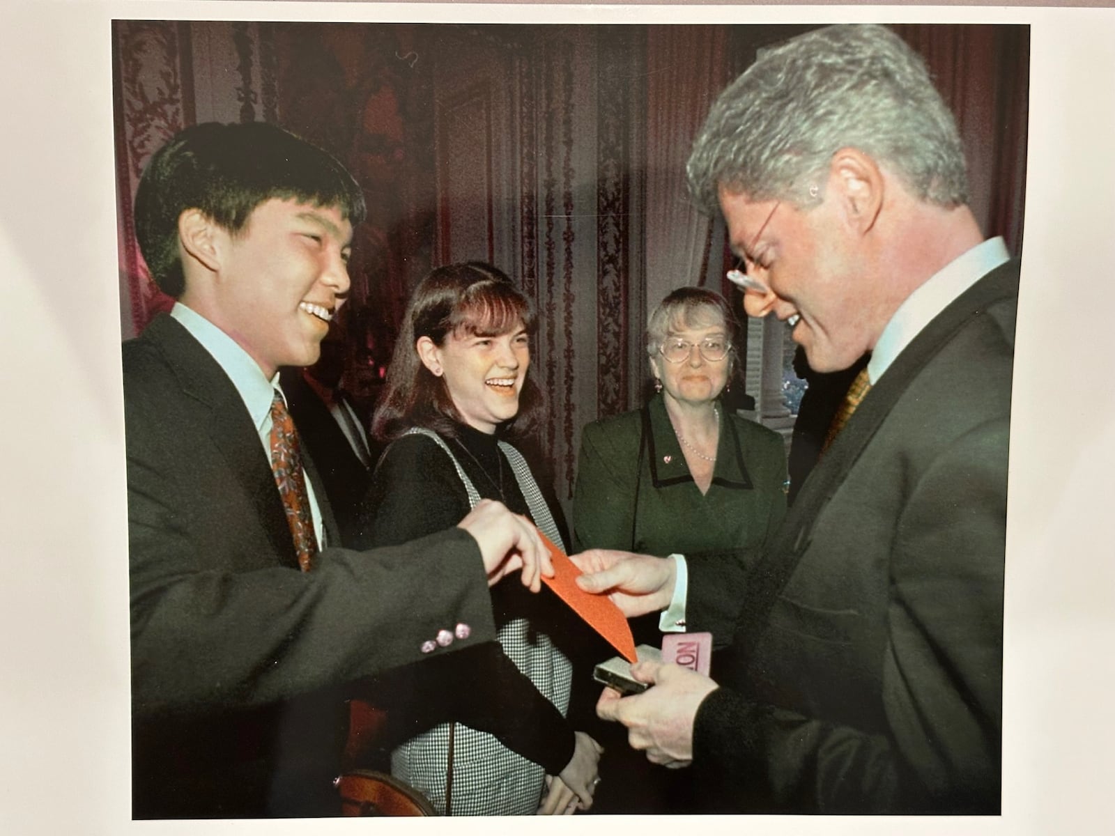 John Kim gives Bill Clinton his family's Christmas card as Julie Waszczak and Maija Recevskis look on. (CONTRIBUTED)