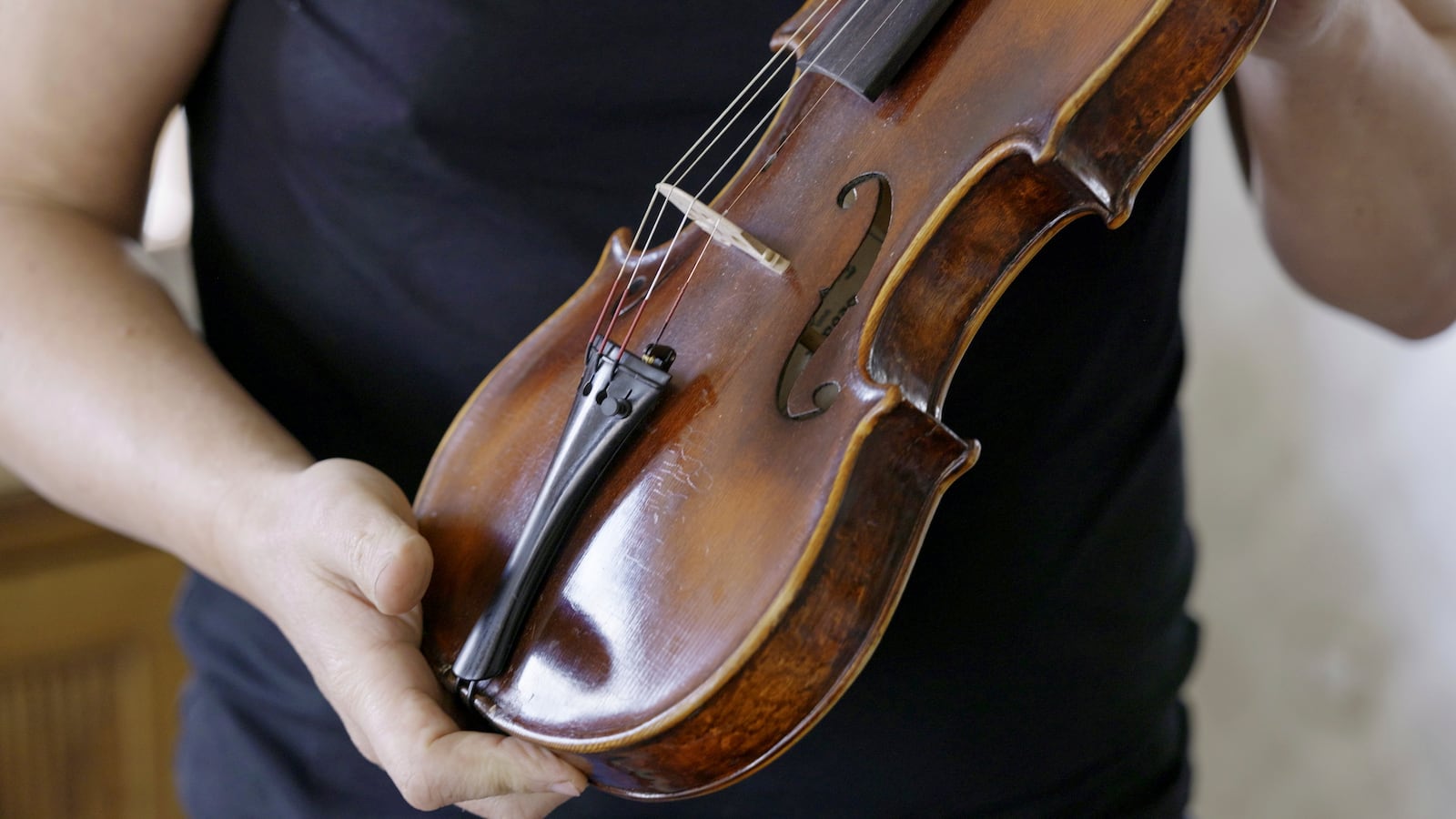 A man holds a Dachau-built instrument dubbed the ''violin of hope'', in Magyarpolány, Hungary, Tuesday April 22, 2025. (AP Photo/Nikolett Csanyi)