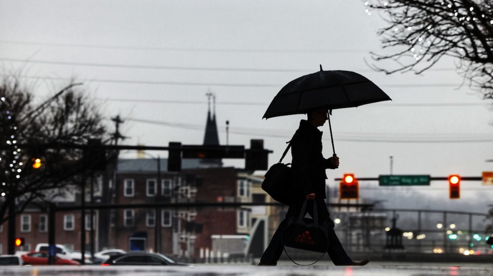 A man holds an umbrella as he crosses High Street in the rain Wednesday morning, Jan. 24, 2024 in Hamiilton. NICK GRAHAM/STAFF