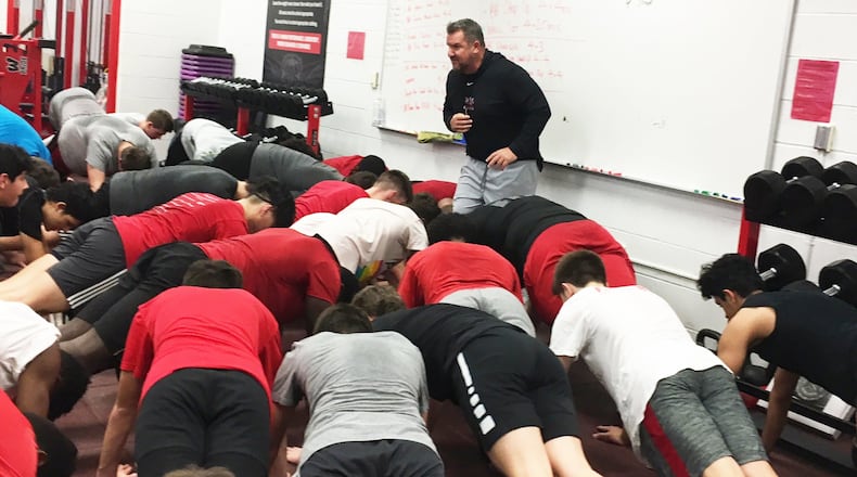 New Lakota West High School football coach Tom Bolden oversees a pushup drill during a workout session at the school Thursday afternoon. RICK CASSANO/STAFF