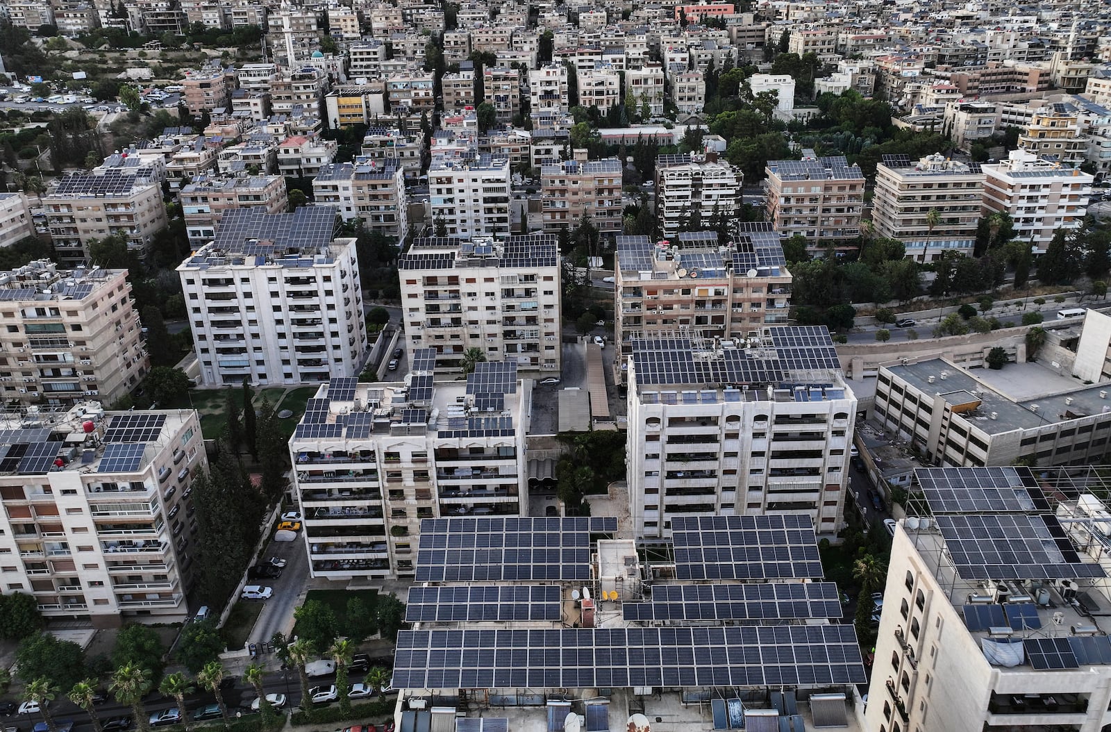 An aerial view shows solar panels installed on building rooftops in Damascus, Syria, Monday, June 30, 2025. (AP Photo/Ghaith Alsayed)