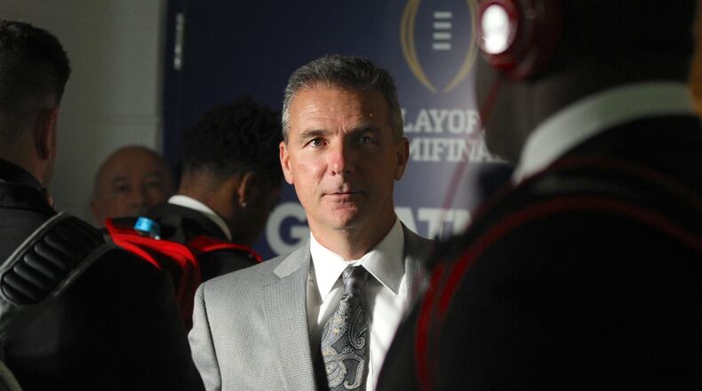 Ohio State’s Urban Meyer greets players as they enter the locker room after arriving at the Fiesta Bowl on Dec. 31, 2016, at University of Phoenix Stadium in Glendale, Ariz. David Jablonski/Staff