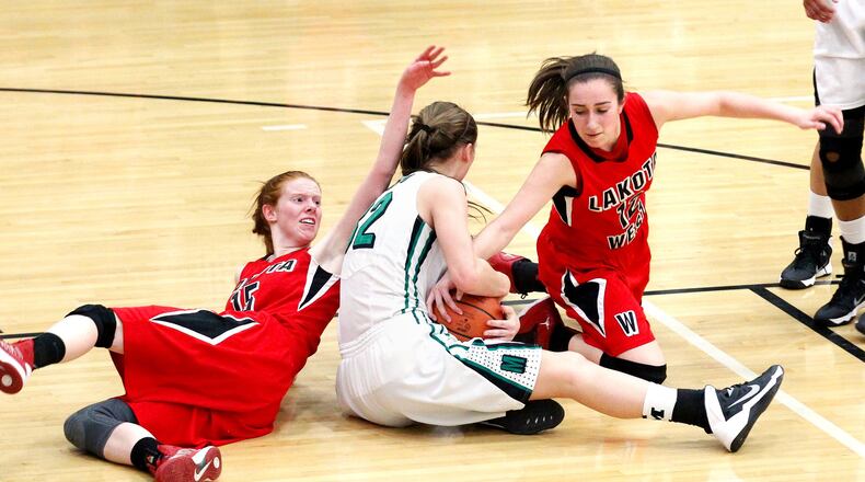 Lakota West’s Elisabeth Carter (left) and Lauren Cannatelli (right) fight for possession of a loose ball with Mason’s Jenna Gunn (32) during a Division I sectional game Feb. 24, 2014, at Lakota East. COX MEDIA FILE PHOTO