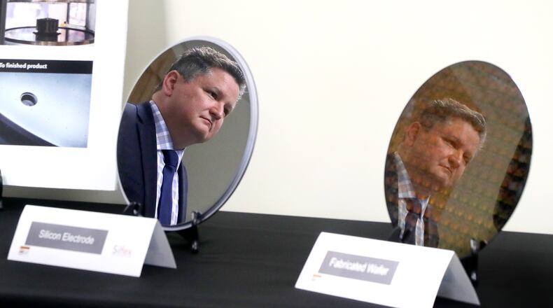 Rob Skrobak, general manager at Silfex, Incorporated, is reflected in a silicon electrode and a fabricated wafer as he listens to Senator Sherrod Brown Wednesday, Oct. 5, 2022. The senator was visiting Silfex to discuss how the recently passed CHIPS Act will support Ohio manufacturers. Silfex produces silicon electrodes and wafers that are used by semiconductor manufacturers to make microchips. BILL LACKEY/STAFF