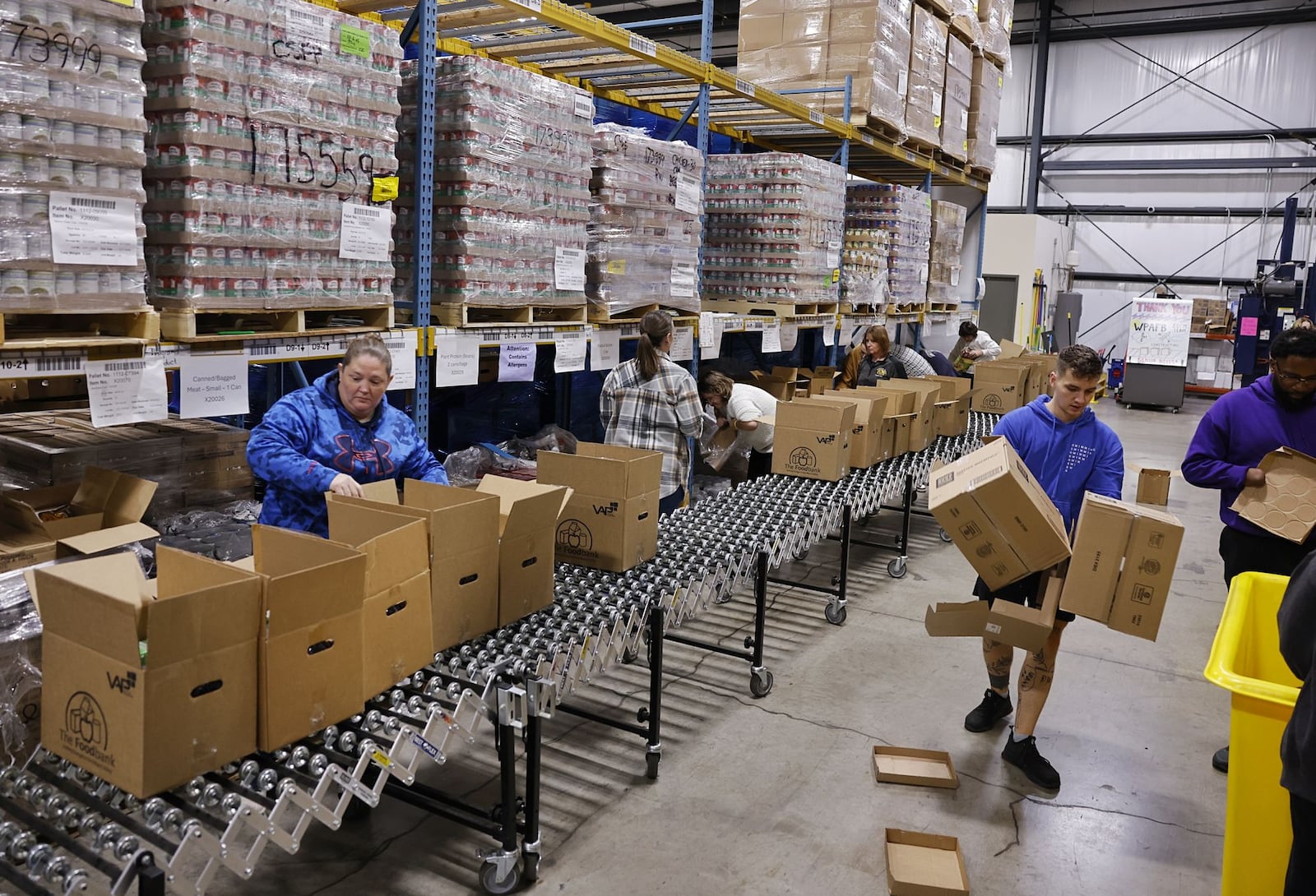 Volunteers pack boxes for delivery to those in need at The Foodbank, Inc. Monday, Oct. 27, 2025 in Dayton. NICK GRAHAM/STAFF