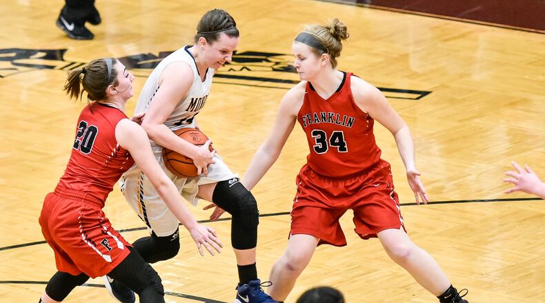 Monroe’s Sophie Sloneker drives to the hoop between Franklin’s Skyler Weir (20) and Brooke Stover (34) during their Division II sectional final Feb. 26 at Lebanon. NICK GRAHAM/STAFF