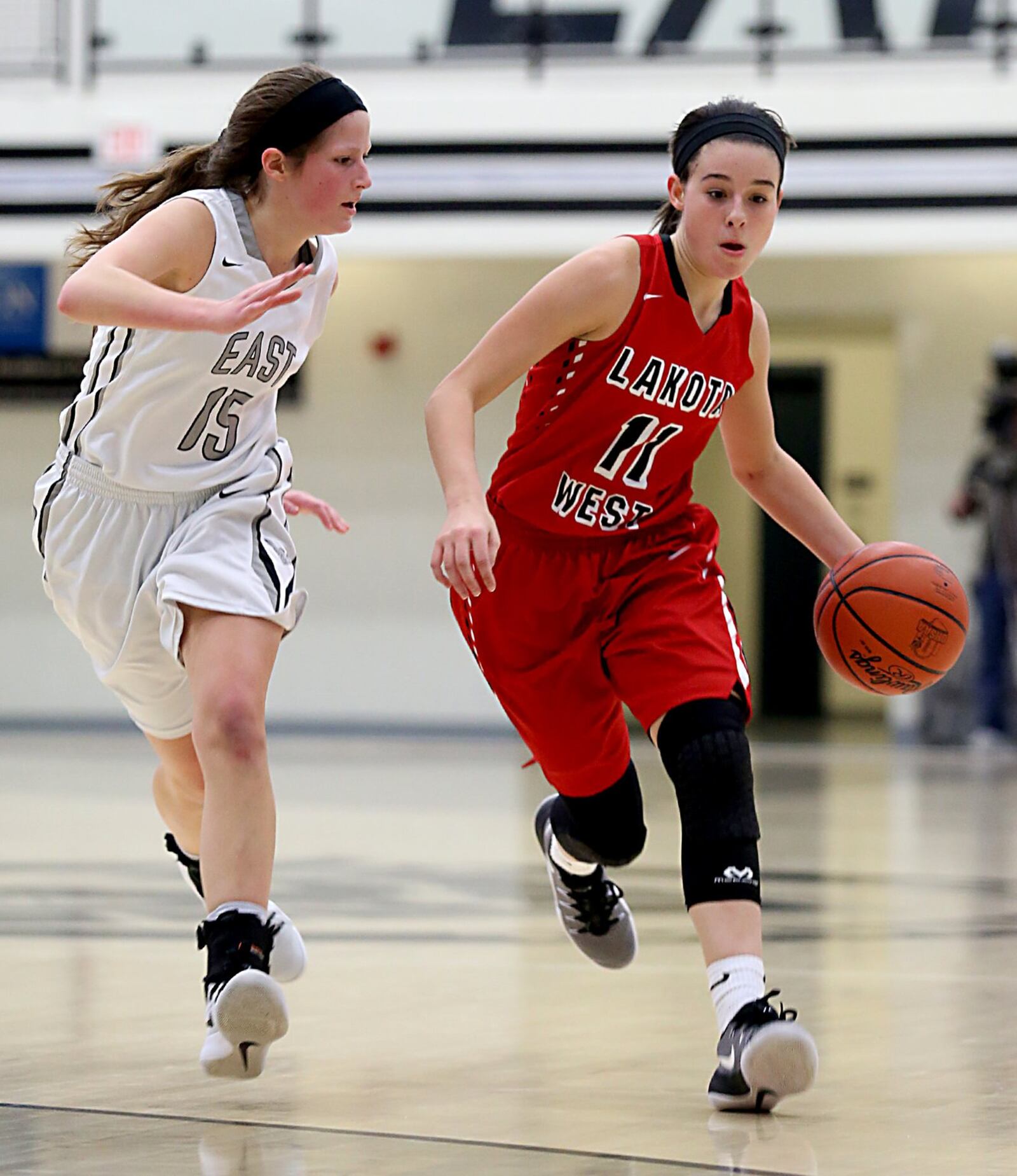 Lakota West guard Madisyn Oxley is followed by Lakota East guard Hannah Kilps during their game in Liberty Township on Wednesday night. CONTRIBUTED PHOTO BY E.L. HUBBARD