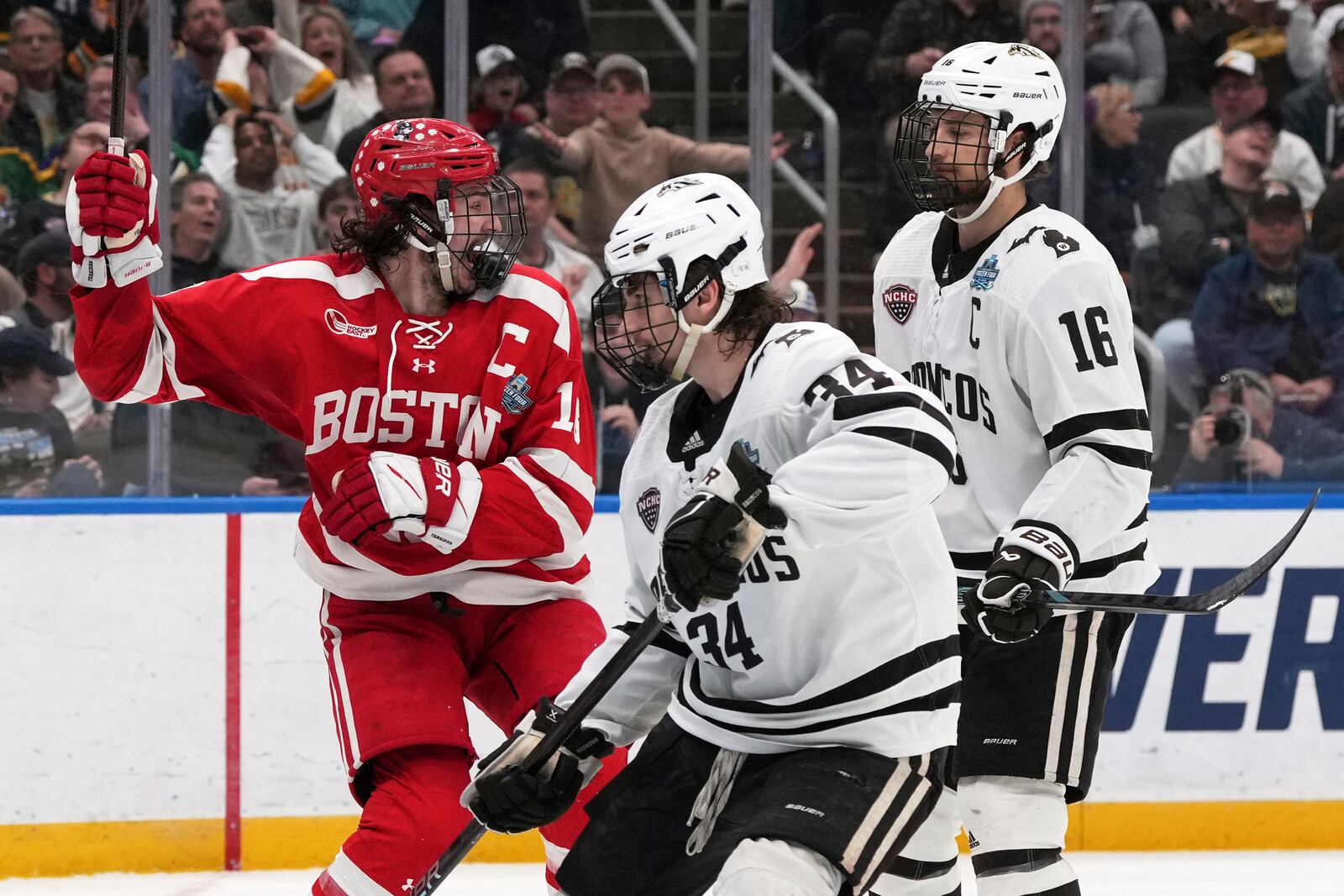 Boston University's Shane Lachance, left, celebrates after scoring as Western Michigan's Owen Michaels (34) and Tim Washe (16) stand by during the second period in the championship game of the NCAA Frozen Four men's college hockey tournament, Saturday, April 12, 2025, in St. Louis (AP Photo/Jeff Roberson)