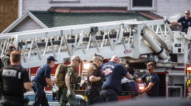 A man climbed down a Dayton Fire Department ladder after he had been on the roof of a Superior Avenue house for about five hours. Dayton police said the man fled into a home and eventually got on the roof after police arrived to take him into custody on felony warrants out of Minnesota. JIM NOELKER/STAFF