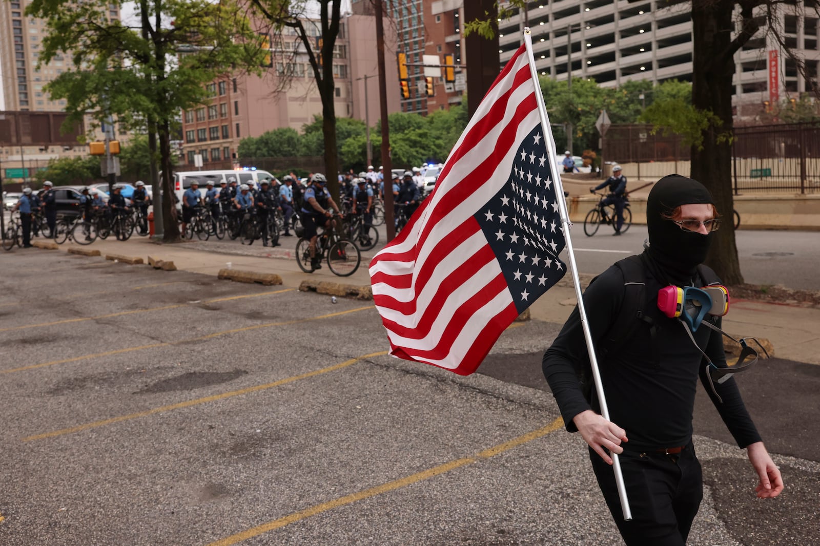 A protestor walks through downtown Philadelphia with an upside down American flag, Saturday, June 14, 2025. (AP Photo/Yuki Iwamura)