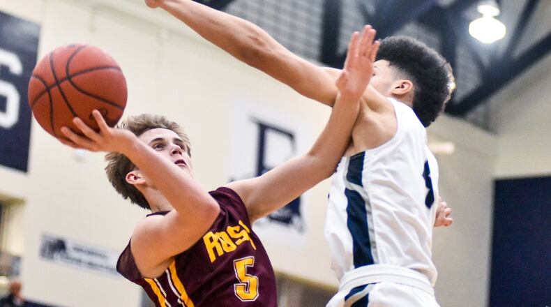 Ben Yeager of Ross puts up a shot defended by Edgewood’s Aaron Frazier during Friday night’s game in St. Clair Township. Visiting Ross won 49-34. NICK GRAHAM/STAFF