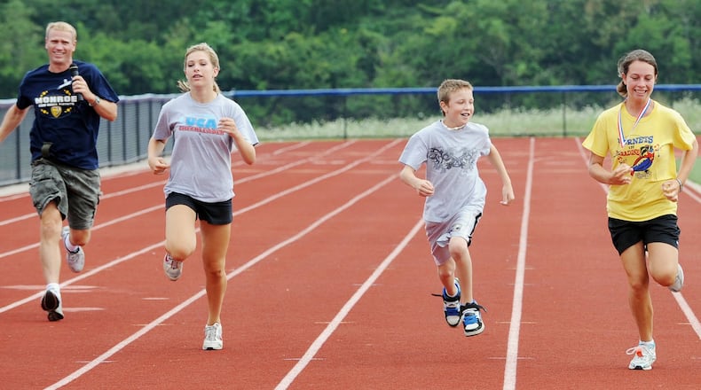 Some area high school stadium running tracks have re-opened after being shuttered for months due to coronavirus prevention measures. The tracks are popular exercise spots for area walkers and joggers like this area family from years past. (File Photo/Journal-News)