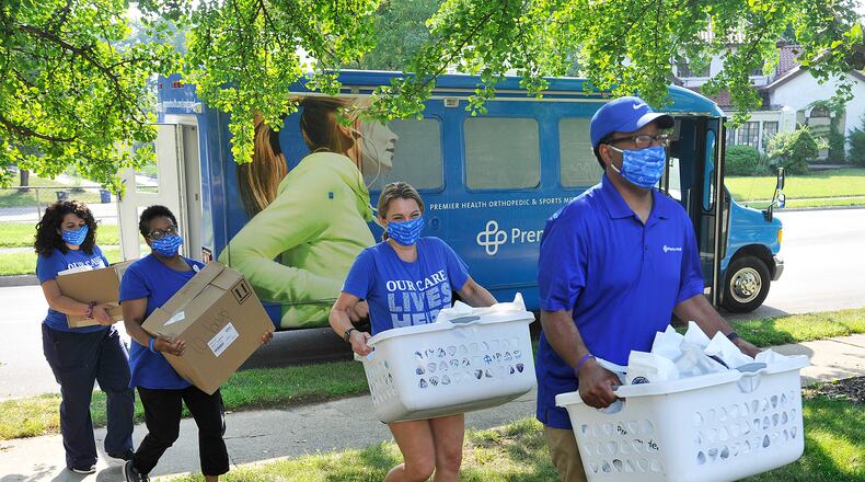 Employees of Premier Health, from left, Shelly Smith, Angy El-Khatib, Cristlyn Johnson and Adrian Taylor, recently delivered to area churches Phillips Temple and Omega Baptist Church deliveries of COVID-19 kits made possible from the 2020 virtual African American Wellness Walk. To help combat the COVID-19 statistics of disproportionate impact to African Americans, all walk proceeds went to fund the COVID-19 kits of masks, hand sanitizer and other supplies. MARSHALL GORBY\STAFF